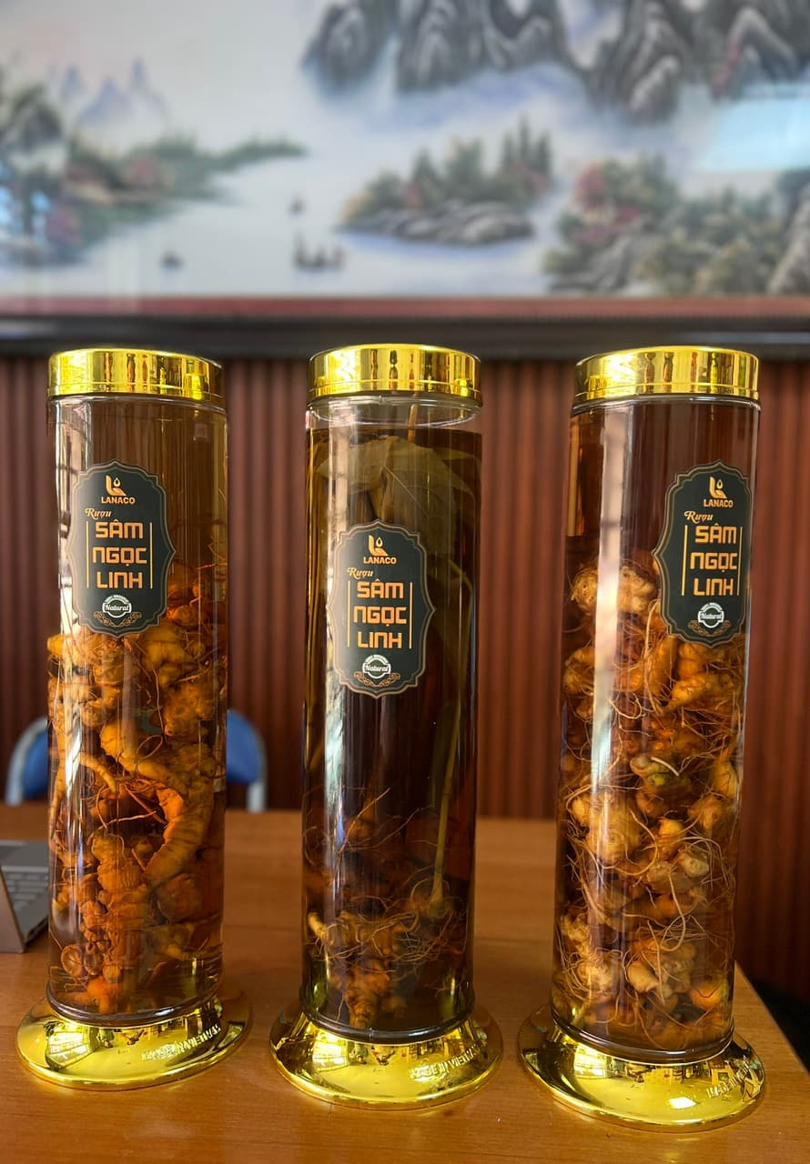 A hand carefully placing a cork into a beautifully designed bottle of dark liquor